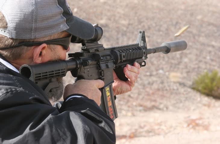 man holding a rifle with an ACOG scope