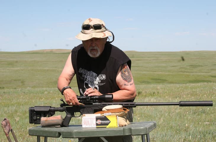 image of a Man holding a gun with a hunting scope