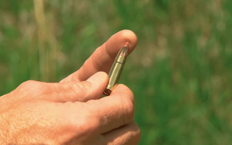 Fingers holding sub sonic round 