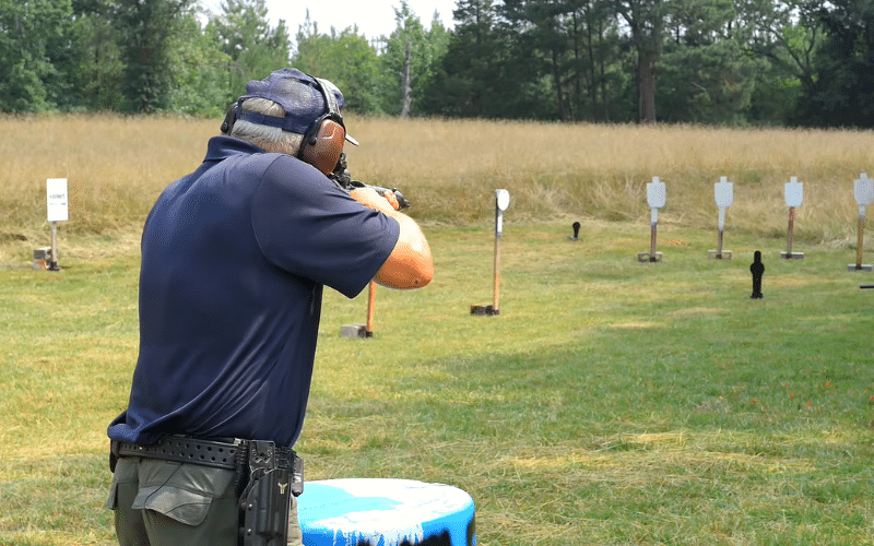 Man shooting a rifle at steel targets in field