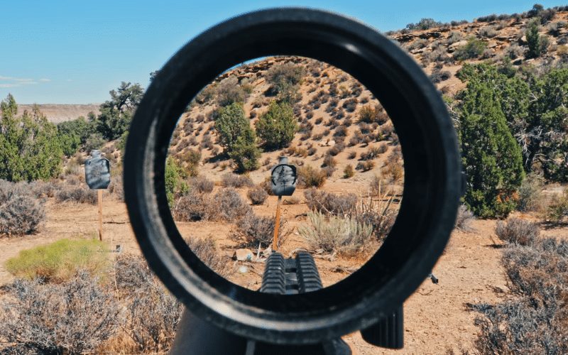 Scope reticle aiming at grey target outdoors