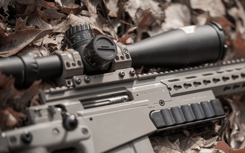 Riflescope mounted on a gun on leaves