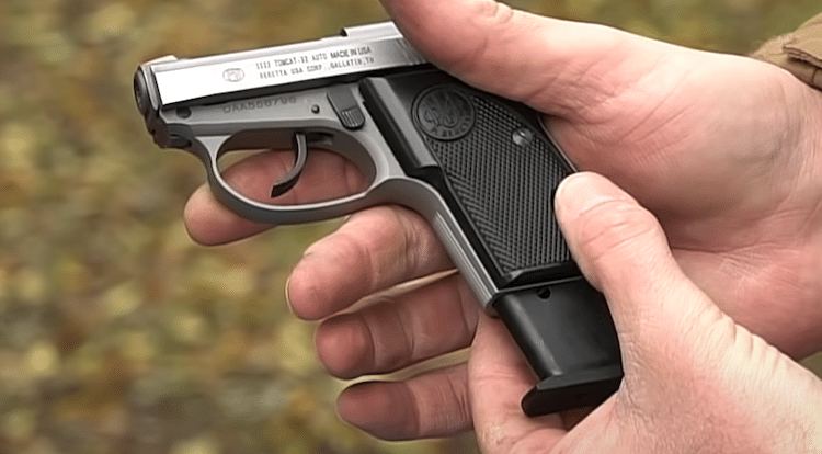 Hands inserting a magazine into the Beretta Tomcat
