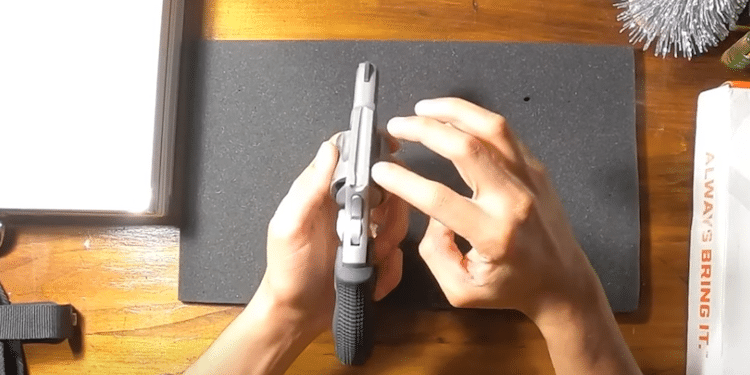 Finger pointing at the spurless hammer on the concealed carry pistol
