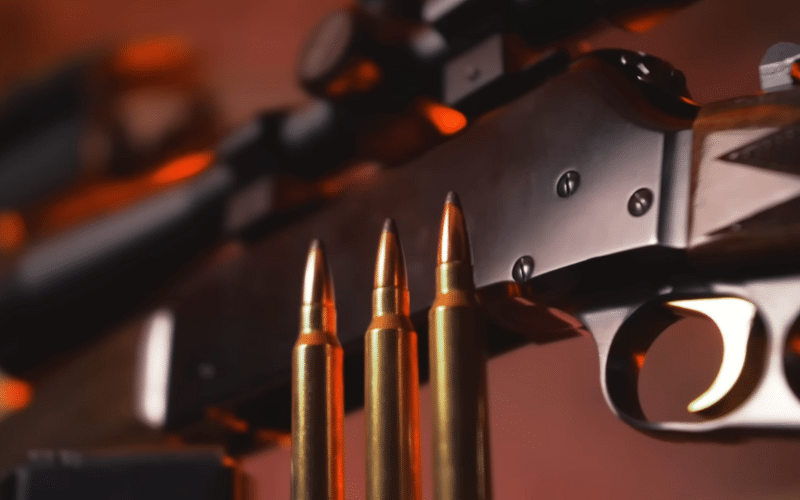 Close up of cartridges and a rifle