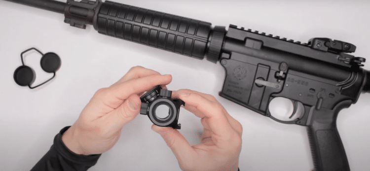 Bushnell Trophy held by two hands, and a rifle on the background