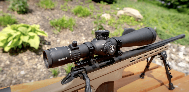 Rifle with a Leupold scope on top of a wooden table