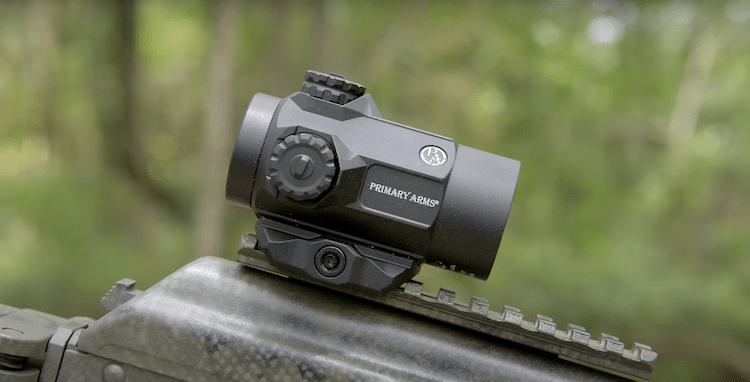 Primary Arms SLx mounted on a rifle, and a blurry background