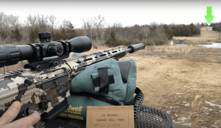 A rifle with a mounted scope aimed at a distant target