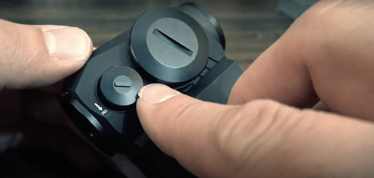 Finger pointed at a knob on a Sig Sauer optic