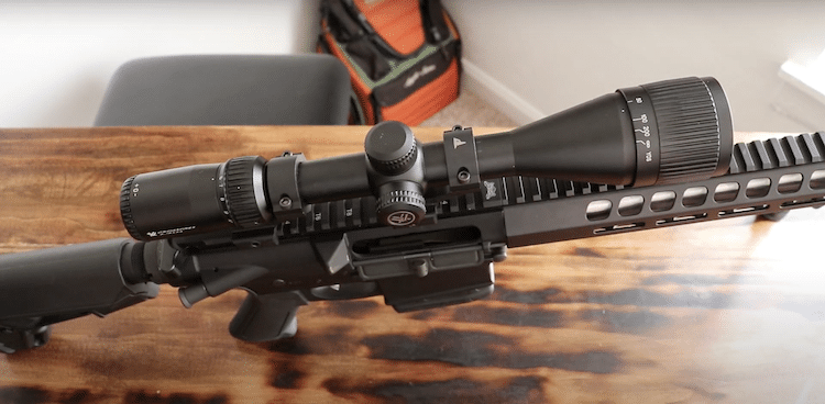 Rifle with a scope on top of a table