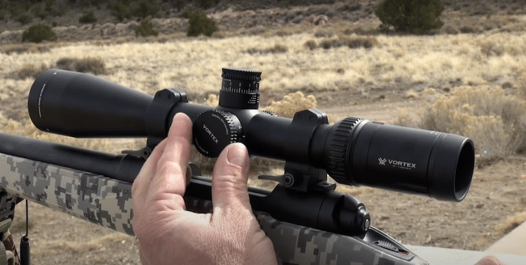 Fingers adjusting the windage knob of a Vortex scope