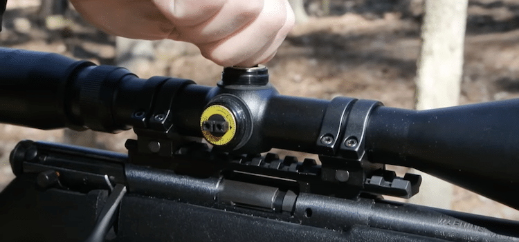 Hand adjusting the elevation knob of a Mueller scope